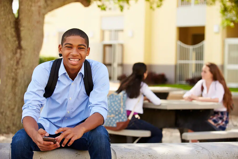 Jeune homme assis sur un banc d'école