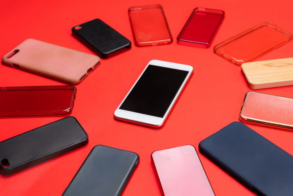 an iphone in a ring of phone cases on a red background