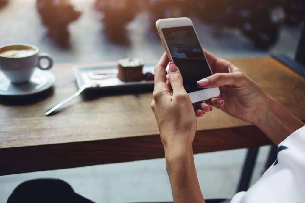 person sitting at a table using their phone