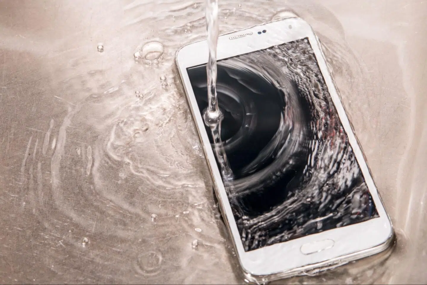 a phone with water being poured on it