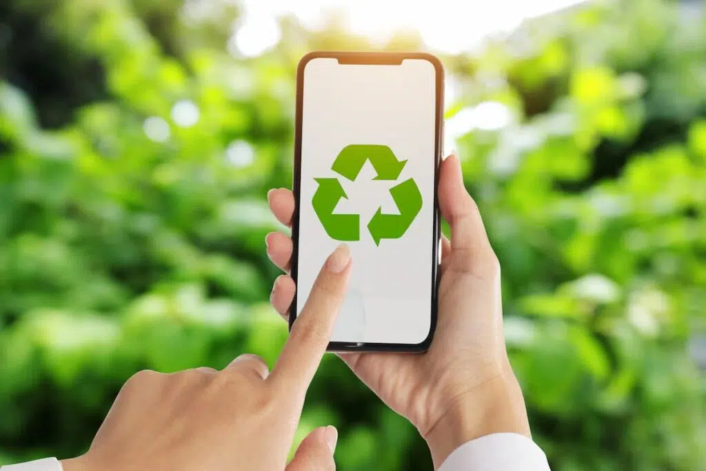 person holding a phone with a recycling icon on it