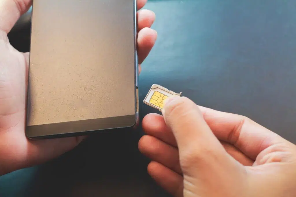 person putting in a sim card into a smart phone