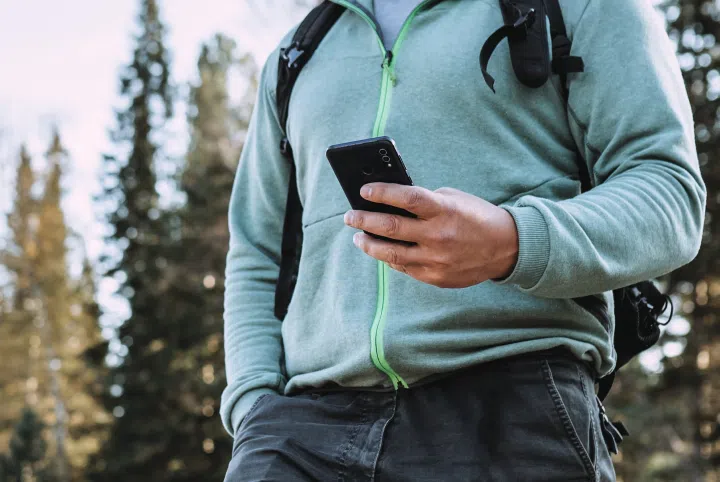 a man in a forest holding a phone