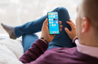 a man sitting in a chair looking at a phone