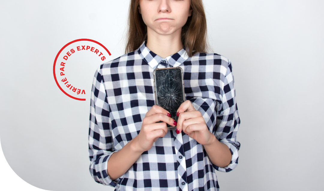 person frowning while holding a broken phone
