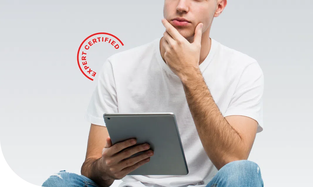 a person sitting while looking up curiously and holding a tablet