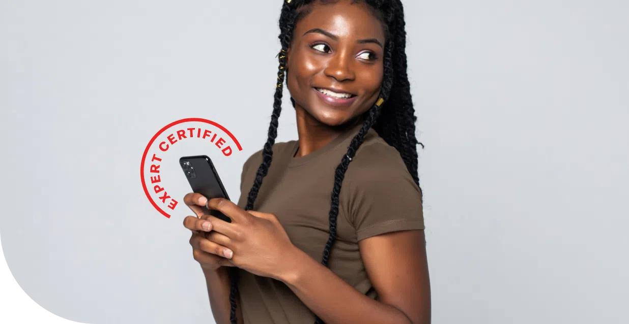 A woman holding a phone up and looking over her shoulder, smiling