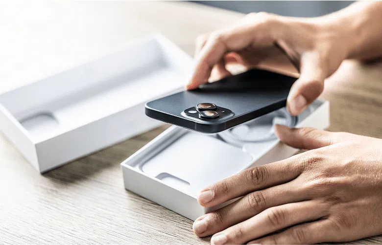 A person placing a phone back into the original box