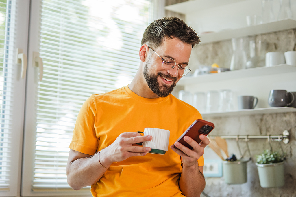 Person using their phone while drinking coffee