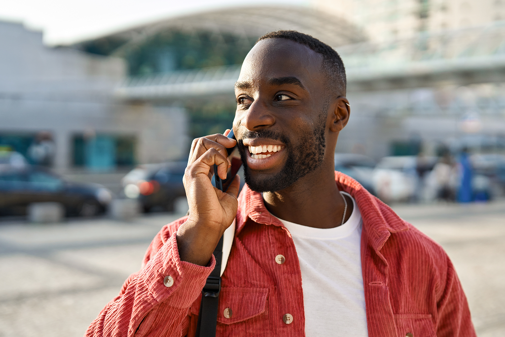 Man outside on the sidewalk talking on the phone